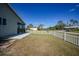 Backyard of home features a large grassy area and a white picket fence at 18086 Clanton Ave, Port Charlotte, FL 33948