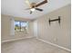 Bedroom with ceiling fan, window, and tile floors at 18086 Clanton Ave, Port Charlotte, FL 33948