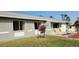 Single story home with gray siding, nicely landscaped yard, and a attached garage at 18086 Clanton Ave, Port Charlotte, FL 33948