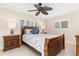 Bright bedroom with wood framed bed, ceiling fan, and tiled floor at 2341 W Marion Ave, Punta Gorda, FL 33950