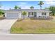 Single story home with attached garage, landscaping and palm trees at 2341 W Marion Ave, Punta Gorda, FL 33950