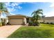 Single-story home with a two-car garage and landscaped front yard at 24667 Rio Villa Lakes Cir, Punta Gorda, FL 33950