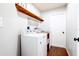 Laundry room with washer, dryer, and wooden shelf at 29350 Goodhue St, Punta Gorda, FL 33982