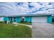 Quaint turquoise house with a large white garage at 3448 Middletown St, Port Charlotte, FL 33952