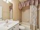 Clean bathroom with tub shower, vanity, and floral shower curtain at 3717 Lakewood Blvd, North Port, FL 34287