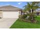 Two-car garage and landscaped front yard with walkway leading to entrance at 3717 Lakewood Blvd, North Port, FL 34287