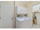 Bright laundry room with washer, dryer, and ample cabinet space at 3717 Lakewood Blvd, North Port, FL 34287