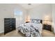 Guest bedroom with floral bedding and dark dresser at 3977 La Costa Island Ct, Punta Gorda, FL 33950