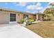 Tan house with a screened porch, garage, and lush landscaping at 420 Chamber Nw St, Port Charlotte, FL 33948