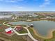 Aerial view of new homes, community park with lake, and walking paths at 44259 Saddlewood Ct, Punta Gorda, FL 33982