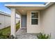 House entrance with gray door, sidelight window, and a stone walkway at 44259 Saddlewood Ct, Punta Gorda, FL 33982