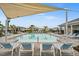 Community pool with lounge chairs and shade structure at 44259 Saddlewood Ct, Punta Gorda, FL 33982