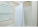 Clean bathroom with a shower, white curtain, and window with blinds at 4522 Mckay St, North Port, FL 34286