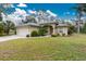 Tan house with a two-car garage and lush lawn at 4522 Mckay St, North Port, FL 34286