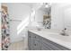 Bathroom boasts double vanity with gray cabinets at 5547 Wagon Wheel Dr, North Port, FL 34291