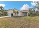 Tan house with a two-car garage, palm trees, and a grassy yard at 5547 Wagon Wheel Dr, North Port, FL 34291