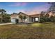 House exterior at dusk, featuring a two-car garage and landscaping at 5547 Wagon Wheel Dr, North Port, FL 34291