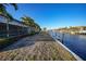 Landscaped backyard features a screened-in pool area and serene canal views at 66 Ocean Dr, Punta Gorda, FL 33950