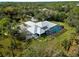 Expansive aerial view of the property showcasing the pool, lush landscaping, and natural surroundings at 700 N River Rd, Venice, FL 34293