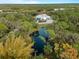 Aerial view of a private estate with a pond surrounded by lush trees at 700 N River Rd, Venice, FL 34293