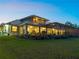 Expansive backyard view with a screened lanai, exterior balcony, manicured lawn, and decorative rock border at 700 N River Rd, Venice, FL 34293