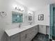 Bright bathroom features modern vanity, dual sinks and glass enclosed shower at 700 N River Rd, Venice, FL 34293