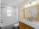 Bright bathroom with a shower and tub combination, a wood vanity and tile flooring at 700 N River Rd, Venice, FL 34293