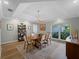 Bright dining room featuring hardwood floors, tray ceiling, and a large window overlooking lush landscaping at 700 N River Rd, Venice, FL 34293