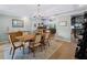 Open-concept dining room adjacent to the living room, featuring a wooden table and decorative rug at 700 N River Rd, Venice, FL 34293