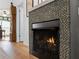 Modern fireplace with stone tile surround at 700 N River Rd, Venice, FL 34293