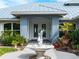 Charming home featuring a front yard water fountain, manicured landscaping, and covered entryway at 700 N River Rd, Venice, FL 34293