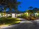 Stunning home exterior featuring manicured lawn, lush landscaping, and a welcoming front entrance at dusk at 700 N River Rd, Venice, FL 34293