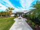 Well-manicured front yard with a decorative fountain, lush landscaping, and a pathway leading to the inviting entrance of this beautiful home at 700 N River Rd, Venice, FL 34293