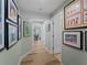 Bright hallway with framed artwork and hardwood floors at 700 N River Rd, Venice, FL 34293