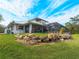 White house with metal roof, screened pool area, and rock retaining wall at 700 N River Rd, Venice, FL 34293