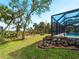 Screened pool and patio area beside lush landscaping at 700 N River Rd, Venice, FL 34293