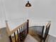 Detail of staircase with light wood handrail and black metal spindles leading to carpeted landing above at 700 N River Rd, Venice, FL 34293