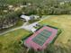 Aerial shot of a private tennis court and surrounding property with lush green lawns at 700 N River Rd, Venice, FL 34293