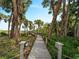 Picturesque wooden walkway through lush foliage offering a serene path to a private backyard retreat at 700 N River Rd, Venice, FL 34293