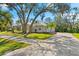 House exterior showcasing a metal roof, landscaping, and a long driveway at 7563 Albert Tillinghast Dr, Sarasota, FL 34240