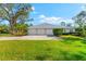 Three-car garage with metal roof and landscaping at 7563 Albert Tillinghast Dr, Sarasota, FL 34240