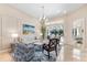 Bright living room features a comfy sofa and chairs, a large window, and elegant chandelier at 7563 Albert Tillinghast Dr, Sarasota, FL 34240