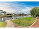 Grass lawn and brick path alongside peaceful canal at 820 Via Tunis, Punta Gorda, FL 33950