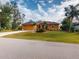 Single-story house with an orange exterior and palm trees at 26191 Copiapo Cir, Punta Gorda, FL 33983