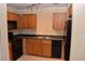 Functional kitchen with wood cabinets, black appliances, and a double stainless steel sink at 108 Pompano Se Dr # D, St Petersburg, FL 33705