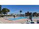 Large inground community swimming pool with lounge chairs, tables, and a view of nearby buildings at 108 Pompano Se Dr # D, St Petersburg, FL 33705