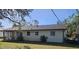 Rear view of house showcasing a screened patio and yard at 1174 Victoria Ave, Port Charlotte, FL 33948