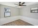 Well-lit bedroom with grey walls, wood-look flooring, and ceiling fan at 1219 Ansin St, Punta Gorda, FL 33950