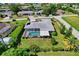 An aerial view showcasing a home with a screened-in pool and lush landscaping at 125 Severin Se Rd, Port Charlotte, FL 33952