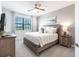 Comfortable bedroom with a king-size bed, large window, and ceiling fan at 14138 Poppy Field Loop # 4122, Punta Gorda, FL 33955
